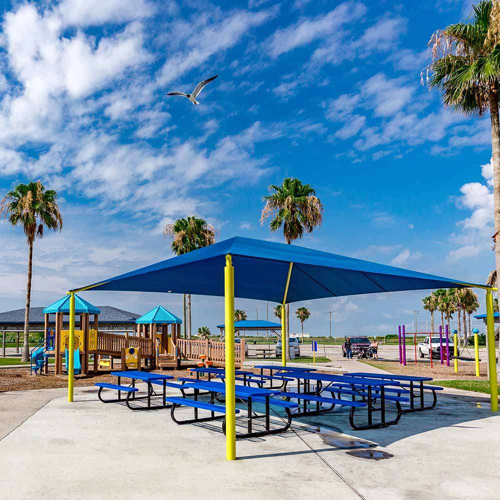 Shade over a picnic area at a park with playground