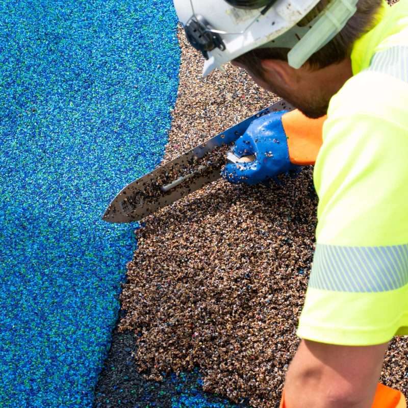 a worker spreading safety surfacing