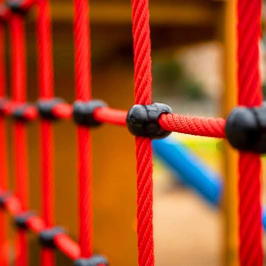 Red and yellow interactive playground equipment with blue wheel