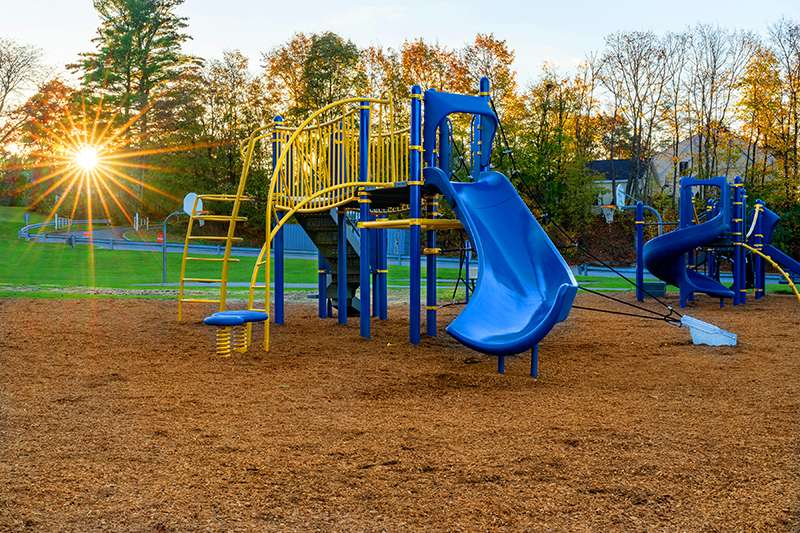 Beige and dark green play structure with a climbing wall