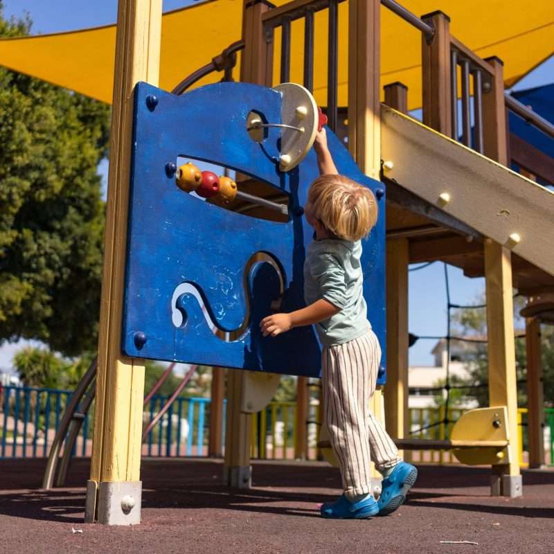 a child playing with an interactive play elements on playground